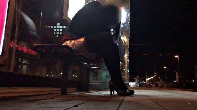 Crossdresser fixed on a bench in a tram station