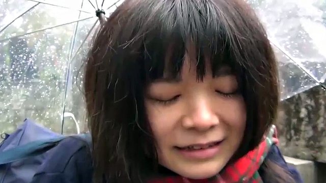 Süßes japanisches Mädchen vergnügt sich im Regen mit einem Vibrator