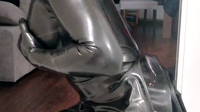 Rubber latex sissy in gas mask plays with a dildo